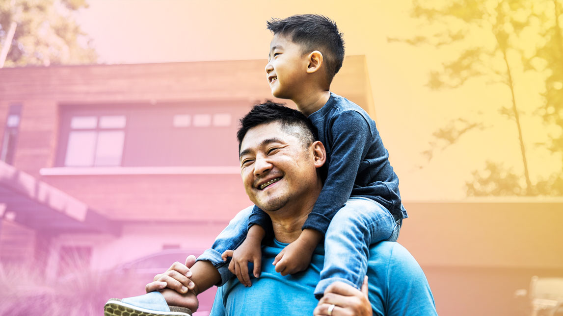 Photo of a man holding his son on his shoulders