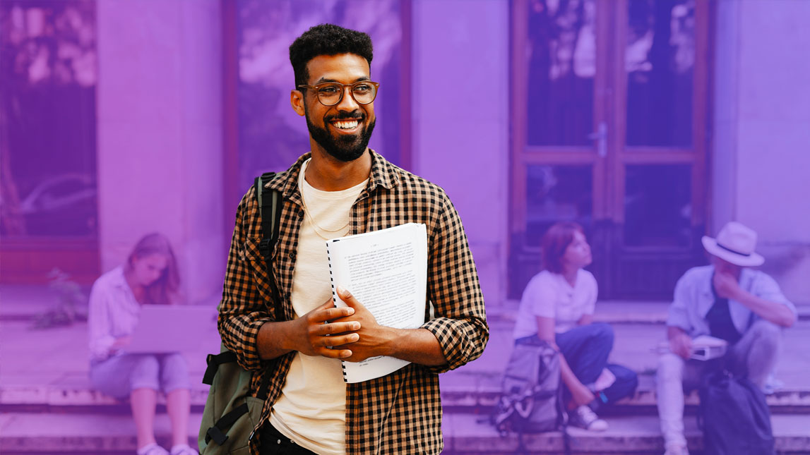 Photo of a university student holding a notebook