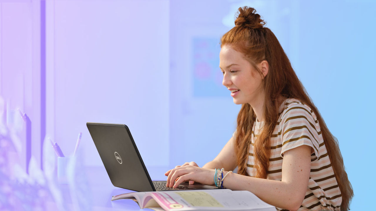 Student with open textbook working on a laptop