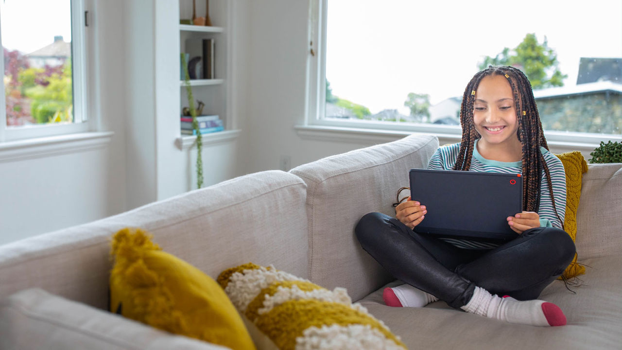 Aprendizaje del estudiante en tableta en el sofá